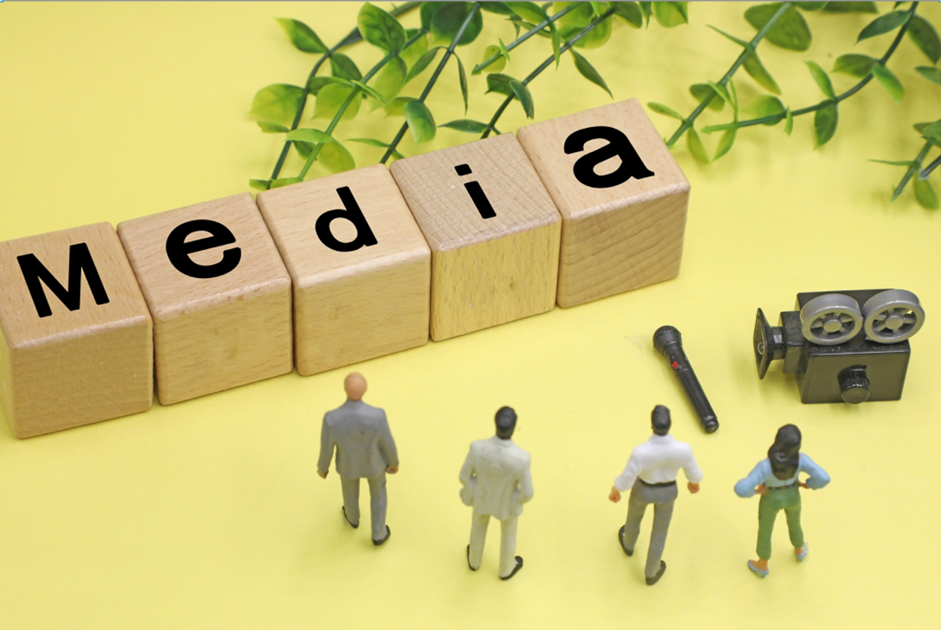 メディアを前にして立つスーツを着るビジネスパーソン4人のイラスト