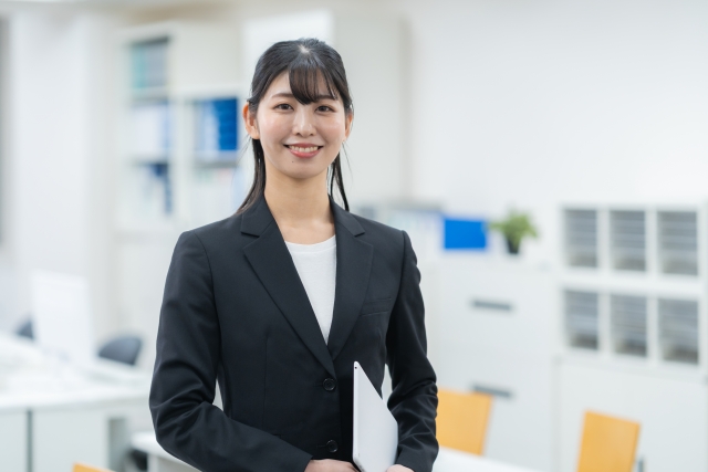 オフィスでスーツを着て立つ美人な女性